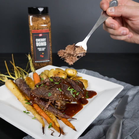 cherry bomb chuck roast with person eating and seasoning bottle in background