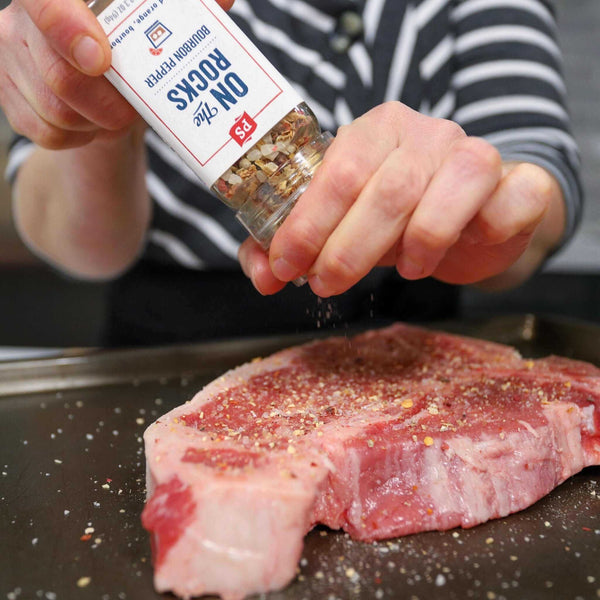 On the Rocks Seasoning Blend being used on an uncooked steak