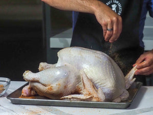 Turkey being sprinkled with Poultry & Fowl Honey Cure made by PS Seasoning.