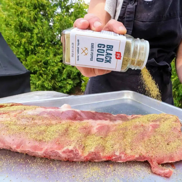 Black Gold being used to heavily season a rack of ribs.