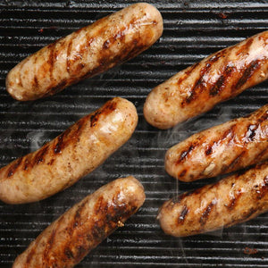 Five Maple Pork Sausage sizzling on the grill.