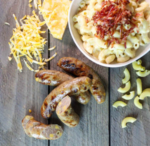 Bacon Mac & Cheese Brat along with a bowl of mac and cheese, and shredded cheese.