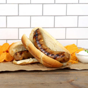 Cheddar and Sour Cream Brat in front of a handful of ships and a block of cheese.