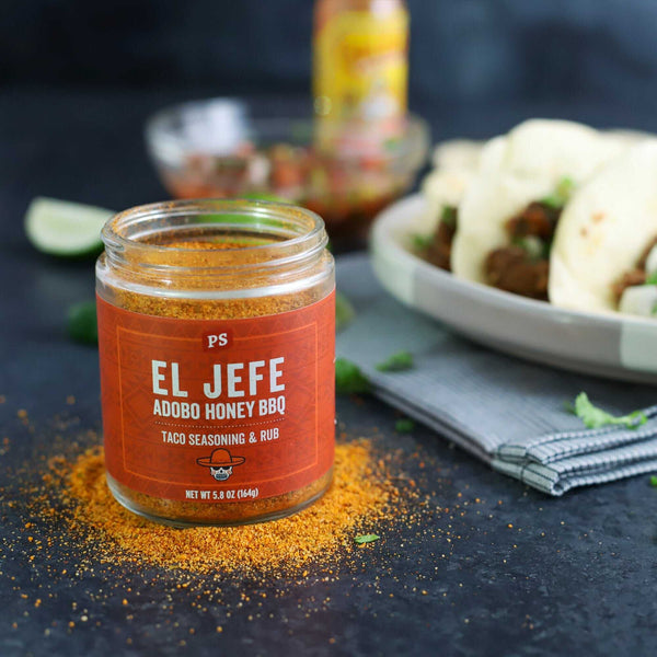 An open can of El Jefe Taco Seasoning with some of the seasoning on the table.