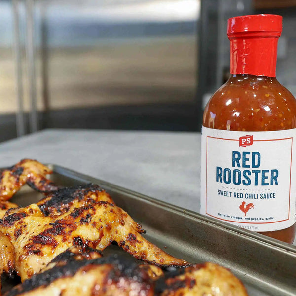 Pan of Thai Curry Wings with a bottle of Red Rooster