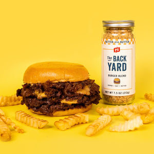 The Backyard Buttery Burger Seasoning next to The Back Yard Signature Burger and scattered fries.