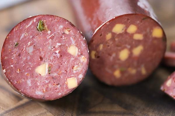 Cut in half summer sausage made with high temp cheddar cheese.