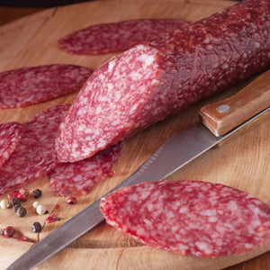 Cut up Beer Salami next to a knife.