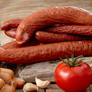 Andouille Sausage made with a mild sausage seasoning. In front of it are some of the ingredients that go into this blend.