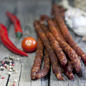 Seven Pepper Snack Sticks next to a tomatoes and red peppers.