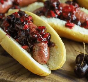 Cherry Cayenne Brat in a bun with cherries on top of it to give it that extra cherry flavor.