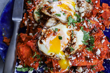 tortillas in a red sauce with fried eggs