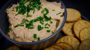 Smoked trout dip in a serving bowl garnished with fresh chives