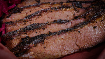Dry aged smoked brisket sliced showing a perfect smoke ring and juicy interior