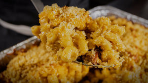 Andouille smoked mac n cheese in a foil pan fresh off the smoker with golden breadcrumb topping