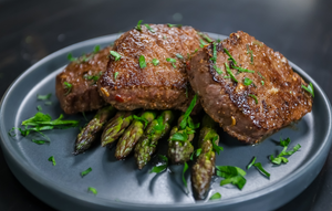Dry aged elk loin sliced and served with asparagus