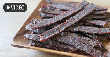 Ground and formed jerky strips pressed from a jerky gun onto a drying rack — ground jerky making method using lean ground beef or venison