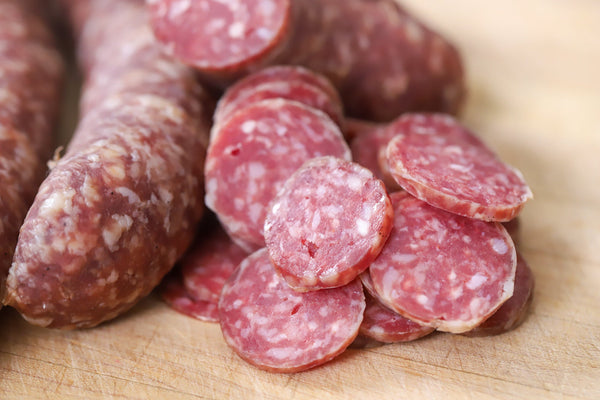 Thermal processed dry aged charcuterie sausages hanging in a dry ager