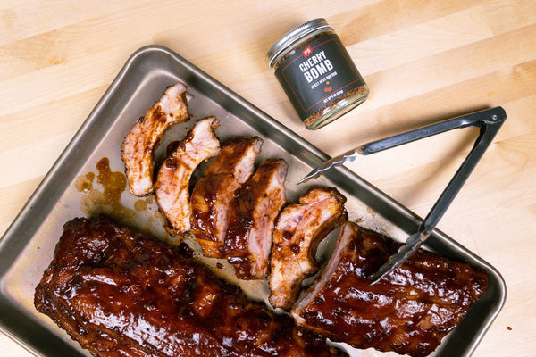 PS Seasoning Cherry Bomb Rub next to a rack of ribs