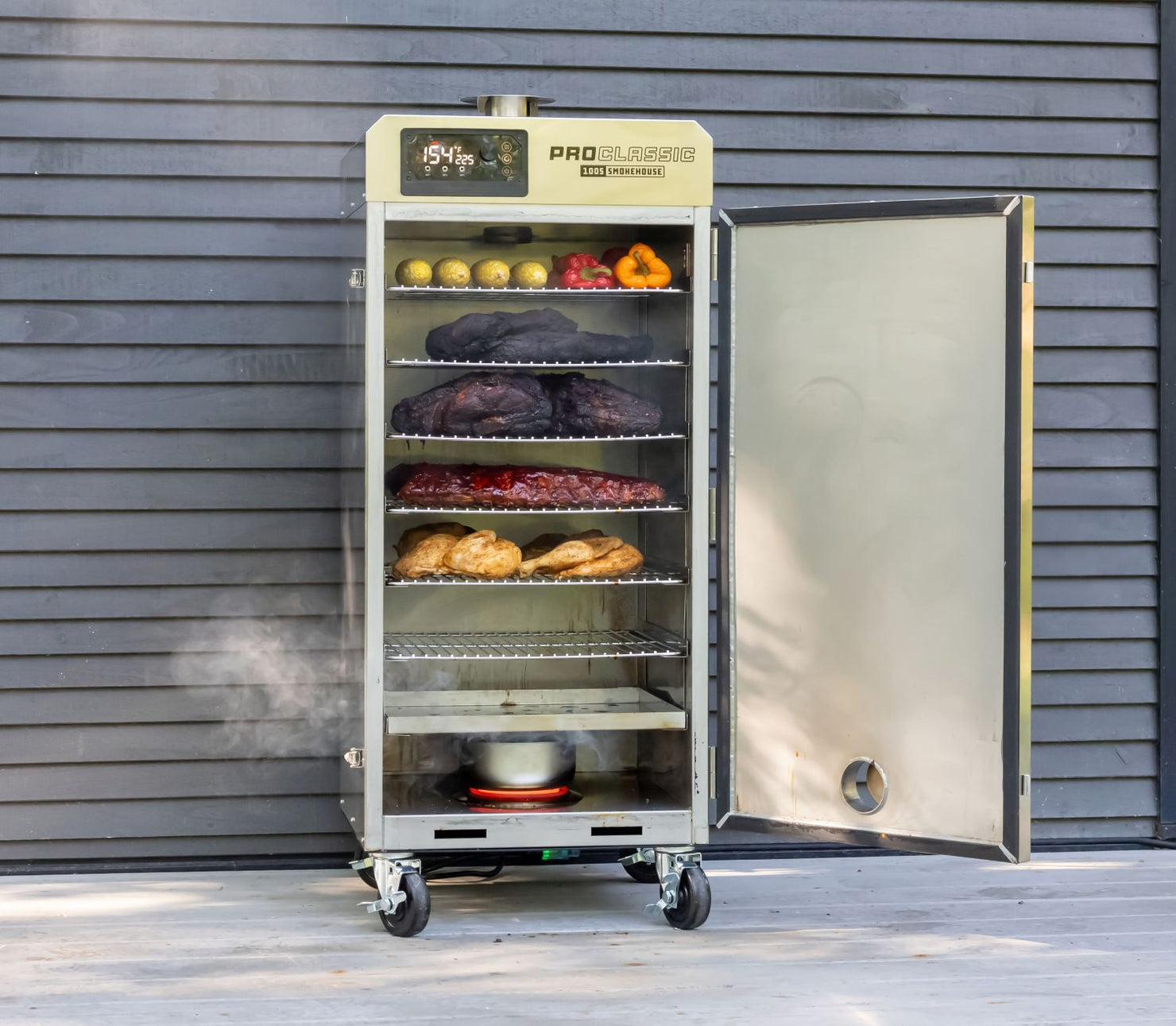 Consumer Pro Classic smoker with food items on shelves against a gray wall.