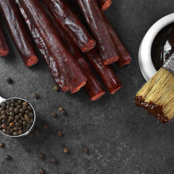 Korean BBQ Snack Sticks next to a cup of BBQ.