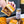 Hand holding a sliced sandwich with a jar of Umami Butter on a table