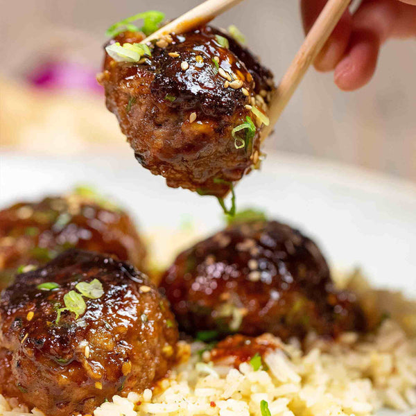 Korean BBQ Meatballs being picked up with chopsticks.