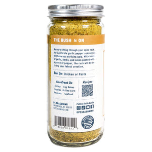 Back view of a glass spice jar with a silver metal lid, showing the product label for PS Seasoning's 'The Rush Is On' spice blend.