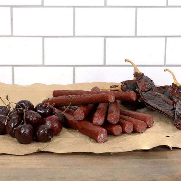 Cherry Chipotle Snack Sticks next to cherries.