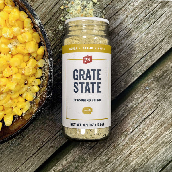 Grate State seasoning blend bottle on a wooden surface with corn.
