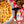 Pizza with sausage pieces on a wooden table with 'Grate State' seasoning blend nearby.