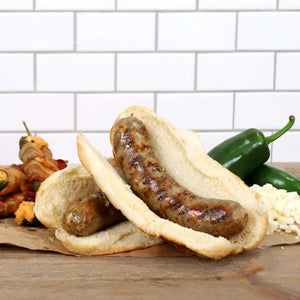 Jalapeno Popper Brats in front of a mixture of ingredients including jalapenos.