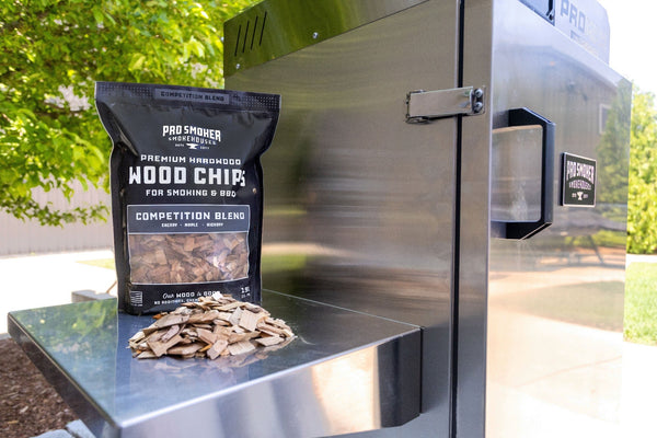 PS Seasoning Pro Smoker premium smoking wood chips — Competition Blend pictured next to a Pro Max 100 S vertical electric smoker