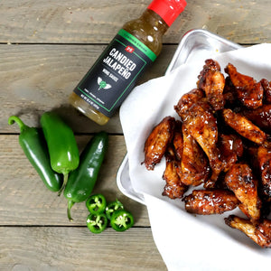 Candied Jalapeno Wing Sauce next to jalapeno peppers and chicken wings