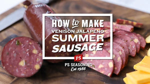 A close-up of sliced venison jalapeño summer sausage on a wooden cutting board, with a large white text overlay reading 'HOW to MAKE VENISON JALAPEÑO SUMMER SAUSAGE'