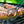 Italian Brats on the grill and a prong being used to flip one of them.