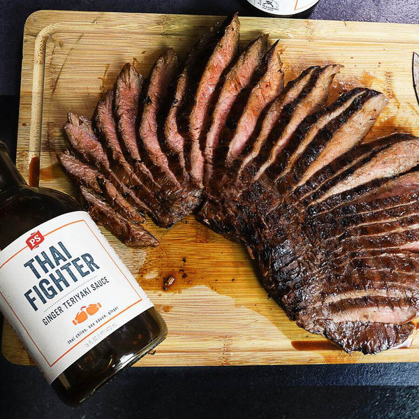 Ginger Teriyaki Flank Steak next to a bottle of Thai Fighter Teriyaki Sauce